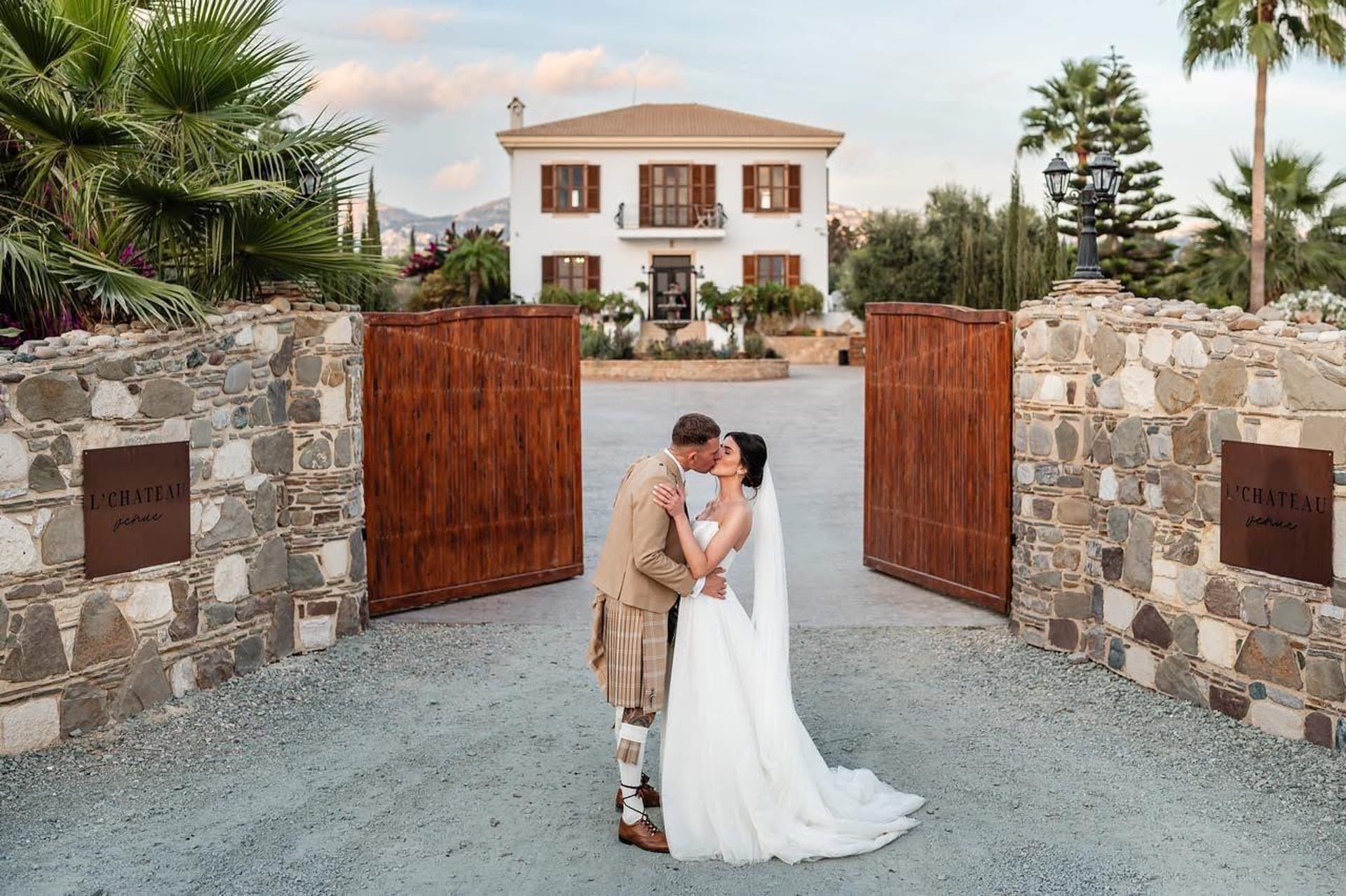 Couple at the gates of a Cyprus wedding estate — destination wedding