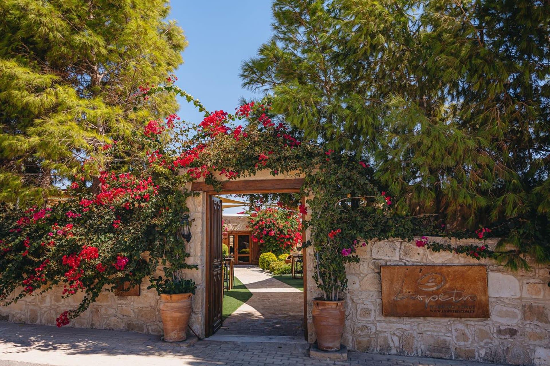Stone entrance archway at Liopetro framed by flowers